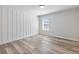 Bright bedroom has wood-look floors, accent wall paneling, and a window that provides natural light at 4437 Hosch Reserve Ct, Buford, GA 30519