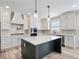 Bright kitchen with an island, stainless steel appliances, pendant lighting and white cabinets at 4437 Hosch Reserve Ct, Buford, GA 30519