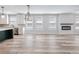 Open concept living space with kitchen island, stainless steel appliances, fireplace, and large windows at 4437 Hosch Reserve Ct, Buford, GA 30519