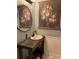 A half-bathroom showing a small vanity sink with a round mirror and flower art at 17 Country Walk, Cartersville, GA 30121