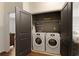 Convenient laundry closet with modern washer and dryer units and additional shelving for storage at 239 S Village Sq, Canton, GA 30115