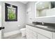 Bright bathroom features a modern vanity with gray counters and framed window at 2804 Skyland Ne Dr, Brookhaven, GA 30341