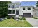 Stunning two-story white brick home with a black garage, modern black window frames, and beautiful landscaping at 2804 Skyland Ne Dr, Brookhaven, GA 30341