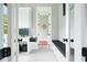 Bright hallway featuring a bench with a view of an office and decorative mirror at the end at 2804 Skyland Ne Dr, Brookhaven, GA 30341
