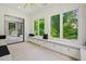 Bright sunroom featuring large windows with lush green views, built-in seating, and modern finishes at 2804 Skyland Ne Dr, Brookhaven, GA 30341