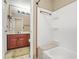 This bathroom features a cherry vanity, tiled floors, and a shower and tub combination at 539 Mcgill Park Ne Ave, Atlanta, GA 30312