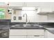 This kitchen features a stainless steel sink with granite countertops, and white cabinets at 539 Mcgill Park Ne Ave, Atlanta, GA 30312