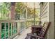 Covered porch area with two wooden chairs, a table, and view to trees and shrubs at 539 Mcgill Park Ne Ave, Atlanta, GA 30312