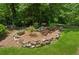 A view of the backyard showing a stone retaining wall and various plants at 6960 Worley Rd, Cumming, GA 30028