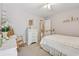 Charming bedroom with light walls, carpet, and rocking chair featuring lots of bright, natural light at 6960 Worley Rd, Cumming, GA 30028