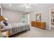 Neutral colored bedroom with a bed, dresser, ceiling fan, and natural light at 6960 Worley Rd, Cumming, GA 30028