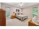 Comfortable carpeted bedroom featuring natural light and ceiling fan at 6960 Worley Rd, Cumming, GA 30028