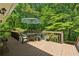 Wooden deck with table and chairs, surrounded by lush greenery and trees at 6960 Worley Rd, Cumming, GA 30028