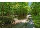 This property features natural foliage and a gravel driveway at 6960 Worley Rd, Cumming, GA 30028