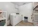 Functional laundry room with washer, dryer, and storage shelving at 6960 Worley Rd, Cumming, GA 30028