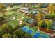 Aerial view of golf course amenities, pool, tennis courts, and club house surrounded by lush greenery at 12162 Mountain Laurel Dr, Roswell, GA 30075