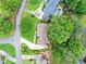Aerial view of home with a lush lawn, mature trees, long driveway and landscape and nearby golf course at 12162 Mountain Laurel Dr, Roswell, GA 30075