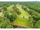 Aerial view of the golf course showcasing the lush greenery, fairways, and tree-lined landscape at 12162 Mountain Laurel Dr, Roswell, GA 30075