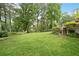 Expansive backyard featuring a lush green lawn, mature trees, and manicured landscaping at 12162 Mountain Laurel Dr, Roswell, GA 30075