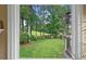 Scenic backyard view through a window showing a lush lawn and serene pond at 12162 Mountain Laurel Dr, Roswell, GA 30075