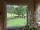 Window view overlooking a serene backyard with pond and lush greenery, offering a peaceful escape at 12162 Mountain Laurel Dr, Roswell, GA 30075