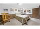 Bedroom featuring a queen-sized bed, wood-paneled accents, a rocking chair, and neutral carpeting at 12162 Mountain Laurel Dr, Roswell, GA 30075