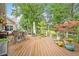 Spacious wooden deck with outdoor furniture, dining area, and lovely views of the surrounding nature at 12162 Mountain Laurel Dr, Roswell, GA 30075