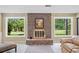 Living room fireplace with brick surround and views of the backyard at 12162 Mountain Laurel Dr, Roswell, GA 30075