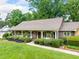 Beautiful single-story home featuring a cozy porch, lush lawn, and mature landscaping at 12162 Mountain Laurel Dr, Roswell, GA 30075