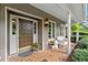 Inviting front porch with decorative tile flooring, potted plants, and stylish outdoor lighting at 12162 Mountain Laurel Dr, Roswell, GA 30075