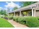 Charming home exterior features a covered porch, manicured landscaping, and a lush green lawn at 12162 Mountain Laurel Dr, Roswell, GA 30075
