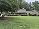 Charming home featuring a beautiful manicured lawn, mature trees, and inviting front porch with decorative plants at 12162 Mountain Laurel Dr, Roswell, GA 30075