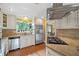 Bright kitchen features a gas cooktop, stainless appliances, light cabinets, and a view into the dining area at 12162 Mountain Laurel Dr, Roswell, GA 30075