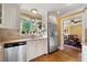 Bright kitchen features stainless appliances, light cabinets, and a view into a dining area with wood floors at 12162 Mountain Laurel Dr, Roswell, GA 30075
