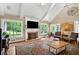 Cozy living room with a fireplace, large windows offering scenic backyard views at 12162 Mountain Laurel Dr, Roswell, GA 30075