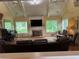 Bright living room with vaulted ceilings, fireplace, hardwood floors, and multiple windows offering scenic views at 12162 Mountain Laurel Dr, Roswell, GA 30075