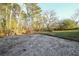 Backyard with gravel and surrounding mature trees at 1496 S Hairston Rd, Stone Mountain, GA 30088