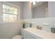 This bathroom features a modern sink and vanity, neutral walls, and a window at 1496 S Hairston Rd, Stone Mountain, GA 30088
