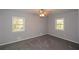 A carpeted bedroom with two windows, and neutral walls at 1496 S Hairston Rd, Stone Mountain, GA 30088