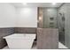 Modern bathroom with a luxurious soaking tub, stylish tiled shower, and a glass enclosure at 206 Grady Burrell Dr, Holly Springs, GA 30115