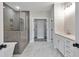 Luxurious bathroom featuring glass shower, herringbone tile, dual sink vanity, and marble-look floors at 206 Grady Burrell Dr, Holly Springs, GA 30115