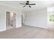 Spacious bedroom boasts neutral walls, carpet flooring, ceiling fan, and attached bathroom with double doors at 206 Grady Burrell Dr, Holly Springs, GA 30115