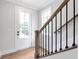 Bright entryway with hardwood floors, staircase, and natural light streaming through the front door at 206 Grady Burrell Dr, Holly Springs, GA 30115