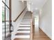 Bright entryway with hardwood floors, staircase, and natural light streaming through the front door at 206 Grady Burrell Dr, Holly Springs, GA 30115