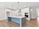 Modern kitchen featuring a large island, white cabinetry, stainless steel appliances, and hardwood floors at 206 Grady Burrell Dr, Holly Springs, GA 30115