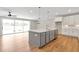 Open-concept kitchen with a large island, pendant lighting, stainless steel appliances, and sliding glass doors at 206 Grady Burrell Dr, Holly Springs, GA 30115
