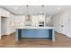 Modern kitchen featuring a large island, white cabinetry, stainless steel appliances, and hardwood floors at 206 Grady Burrell Dr, Holly Springs, GA 30115