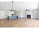 Spacious open-concept living room with wood floors, fireplace, and kitchen island with stylish blue accents at 206 Grady Burrell Dr, Holly Springs, GA 30115