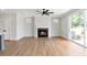 Cozy living room features fireplace with tile surround, ceiling fan, and sliding glass doors to backyard at 206 Grady Burrell Dr, Holly Springs, GA 30115