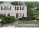 Charming townhouse with red shutters, complemented by a well-maintained front lawn and mature trees, conveniently located near parking at 3371 Spring Harbour Dr, Atlanta, GA 30340